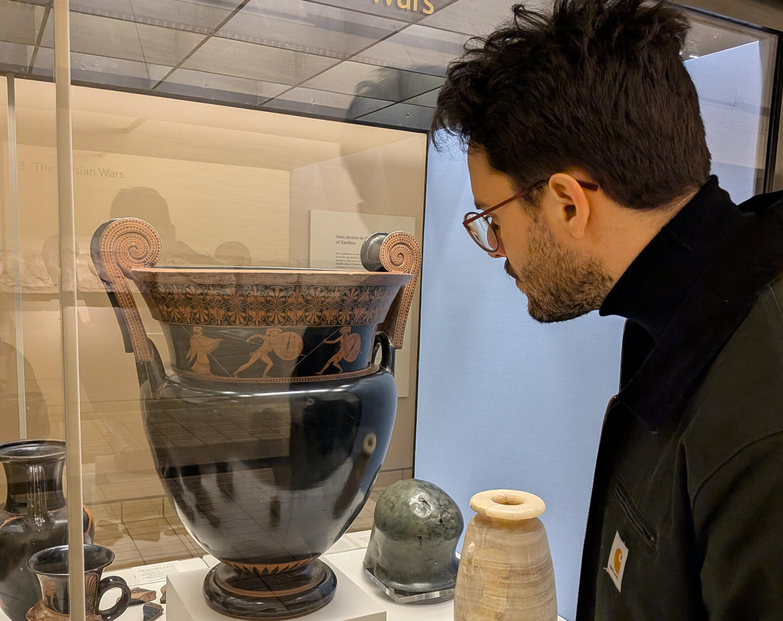 A photograph of an ancient Greek vase painted with an abduction seen in red-figure vase painting style.